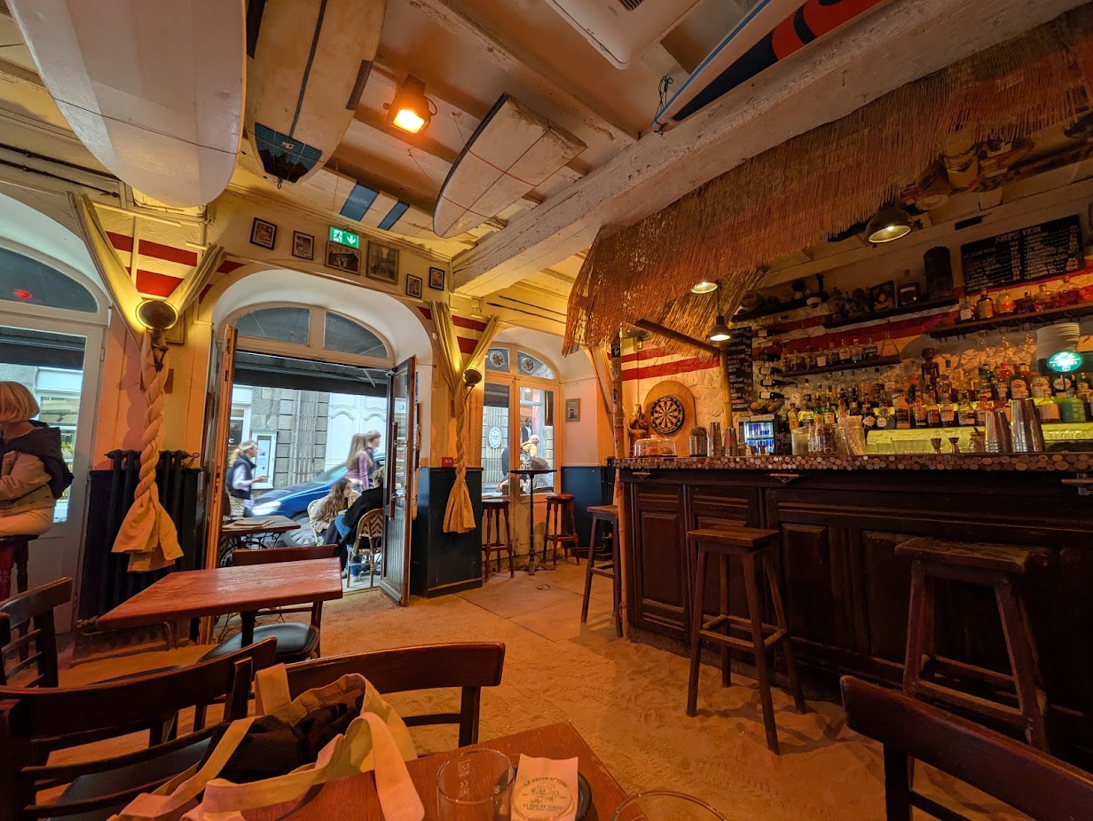 A wide shot showing the bar, with surfboards on the ceiling and tiki style bar