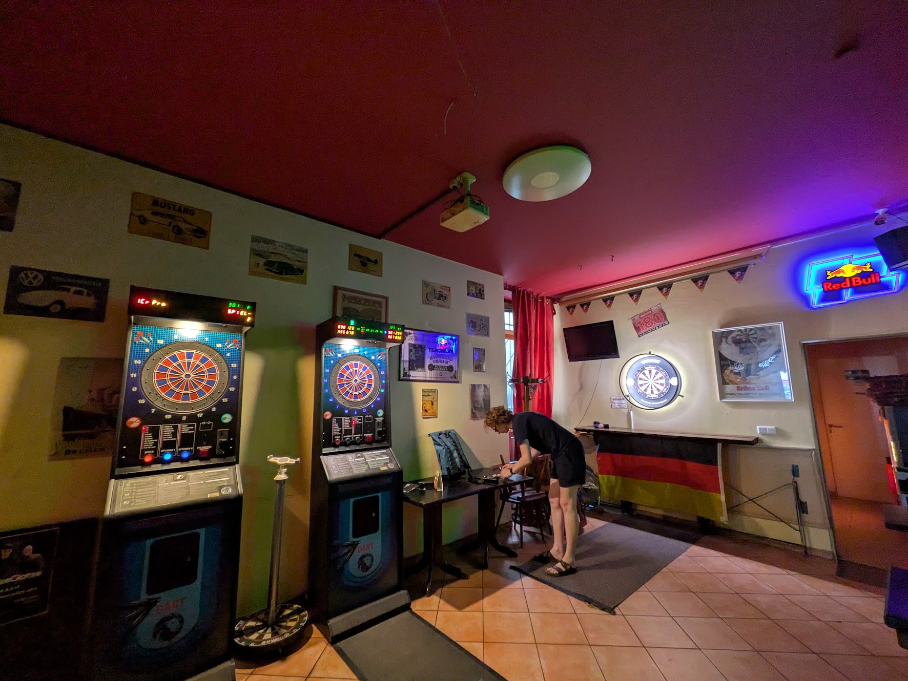A wider picture showing the whole room with 2 soft-tip machines and lots of retro posters on the wall