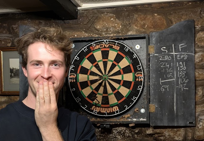 Sam looking amazed at the checkout behind him, a 19 and a bullseye