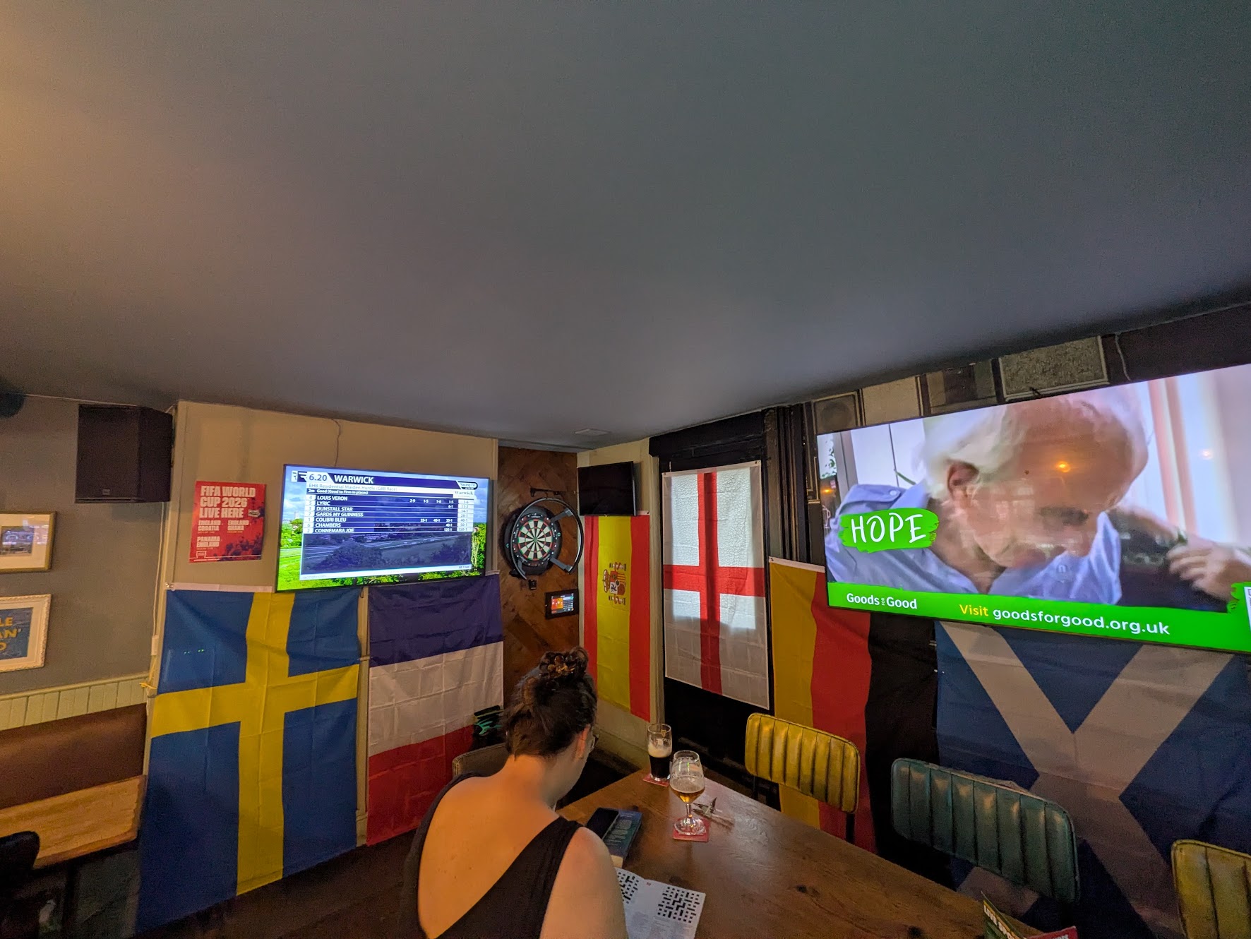 A wider shot of the oche, showing the high table next to it, and the telly behind it