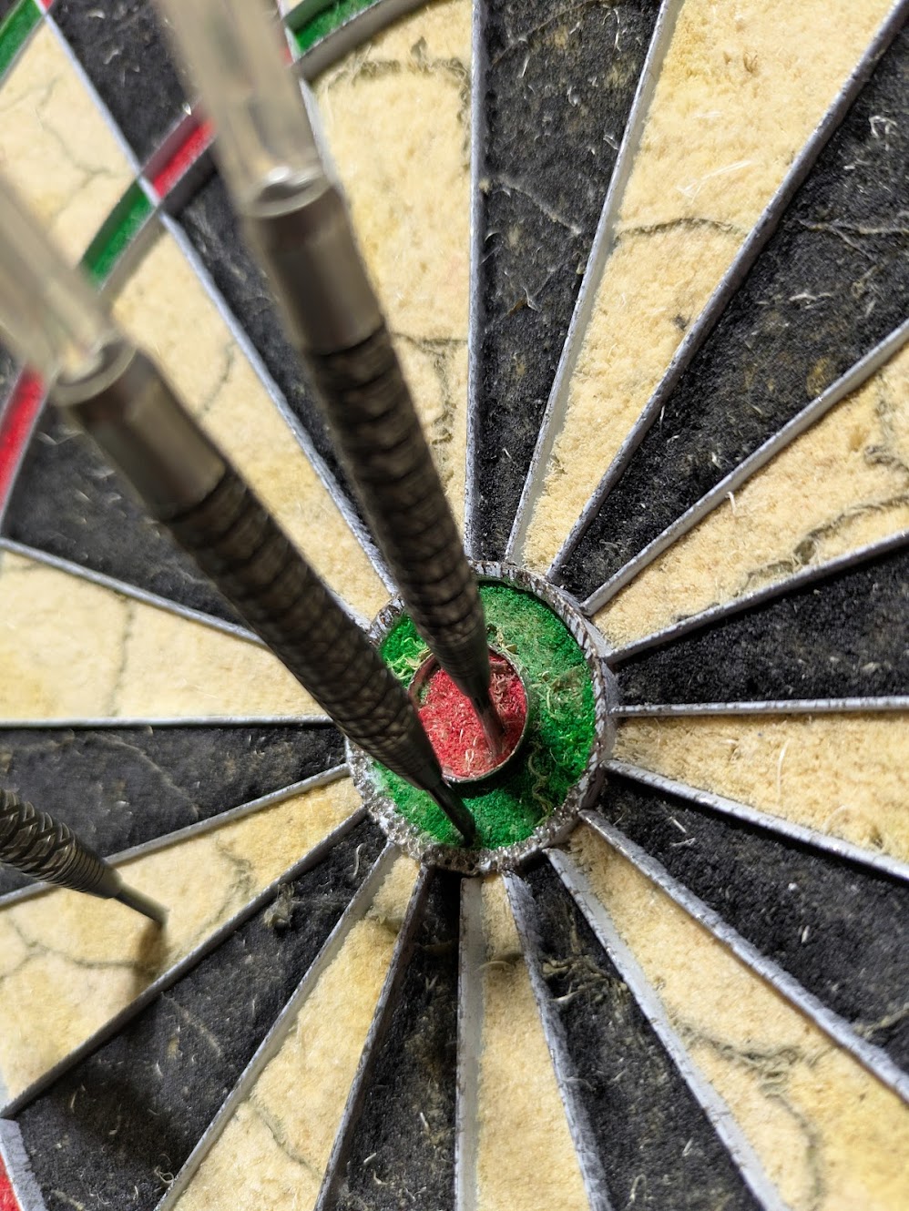 A close up of the bullseye with a couple of arrows in it