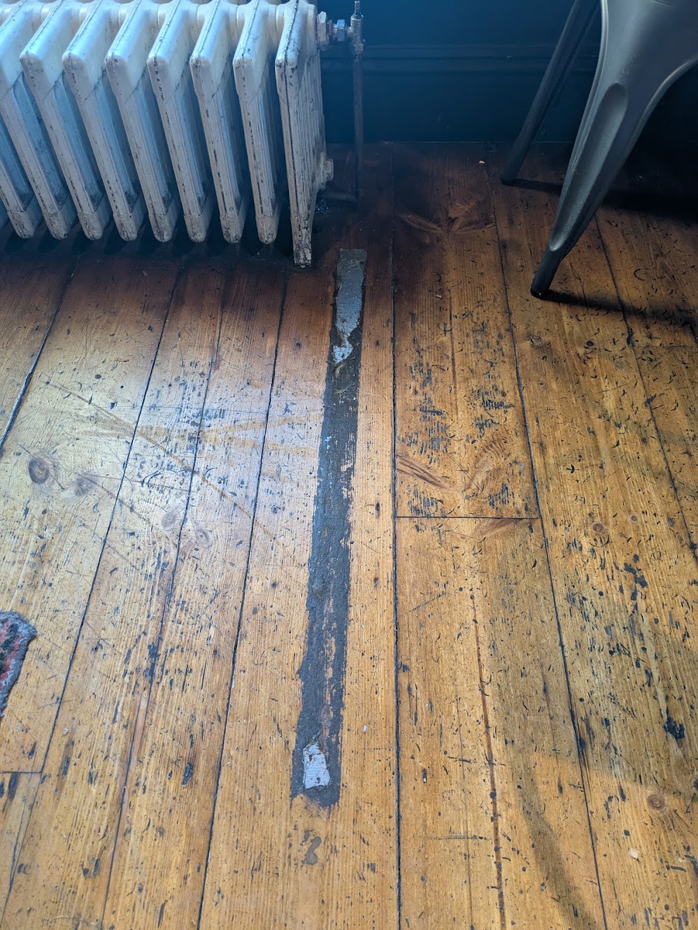the oche is a grubby line on the floor, about a metre long and 2.5cm wide formed of dust sticking to the residue of sticky tape