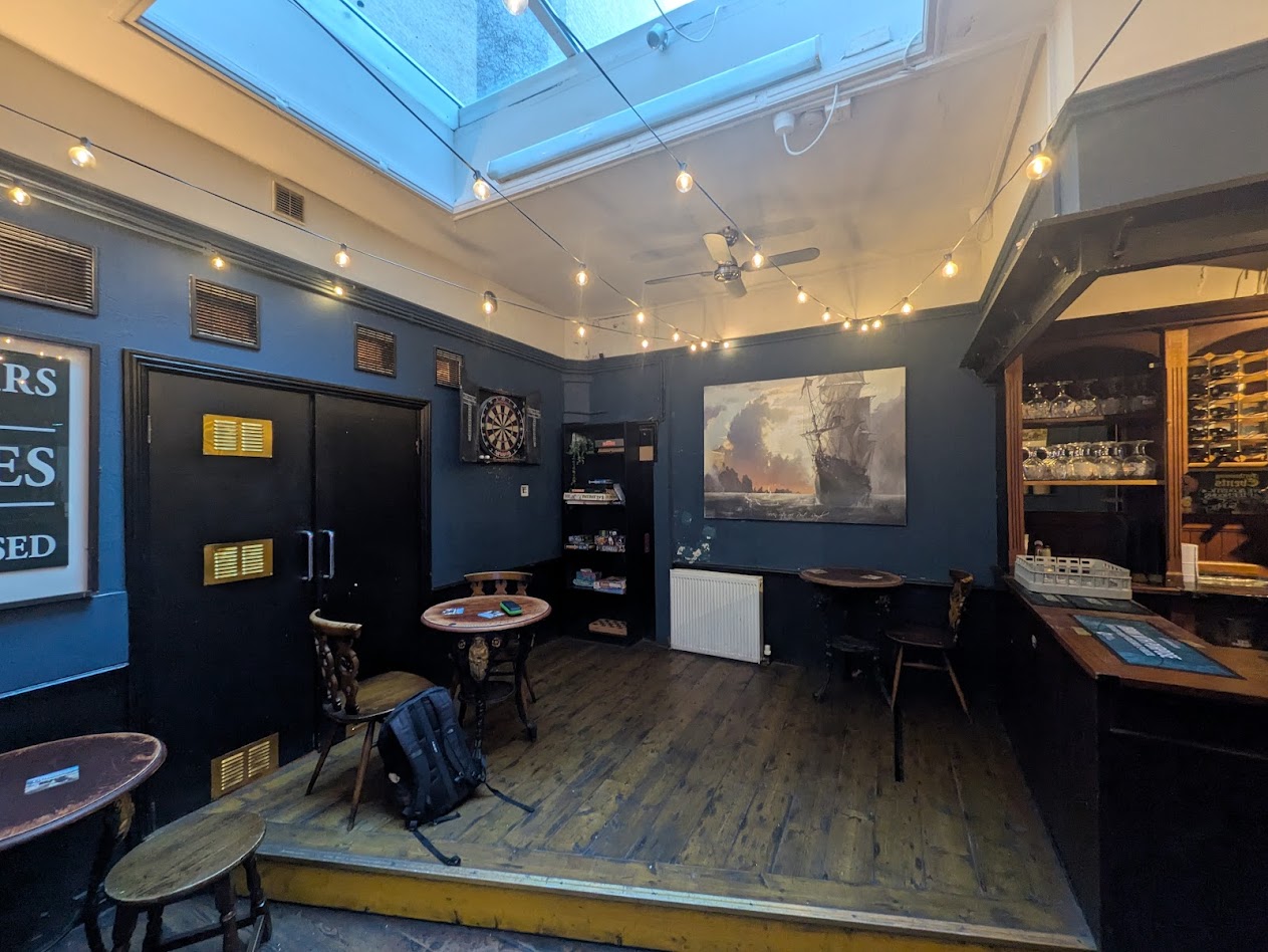 A shot of the whole darts set up. It's in a back corner of the pub, on a small raised stage, with the end of the bar backing onto the oche