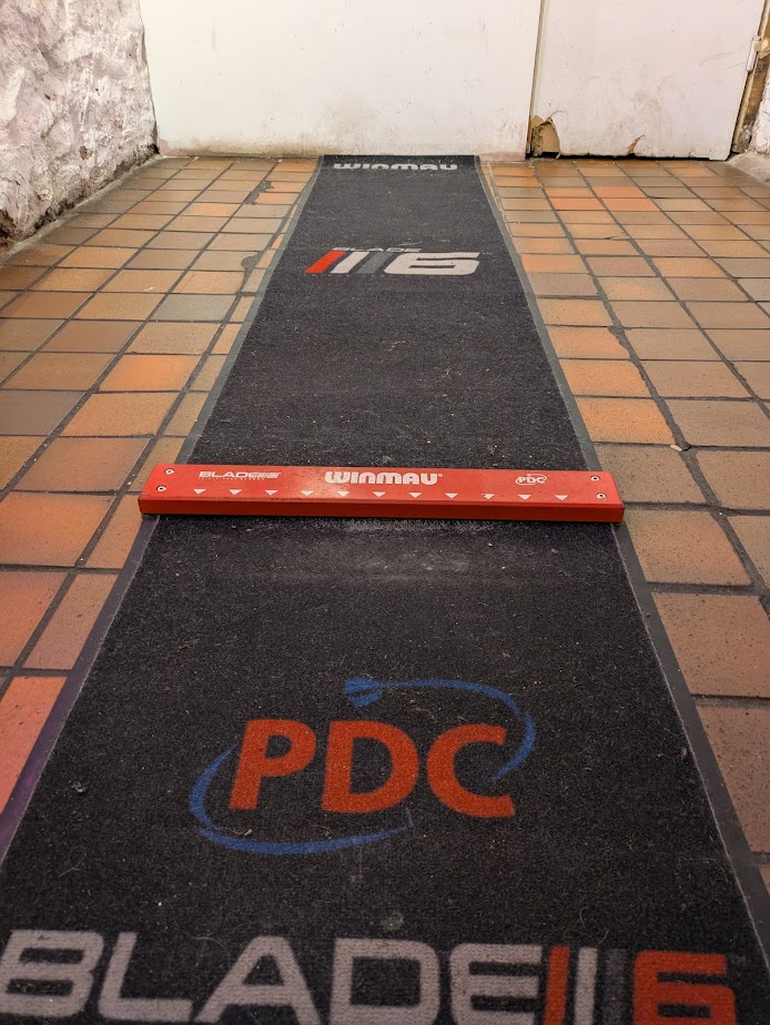 A picture of the oche, a raised plank of wood bolted to the floor